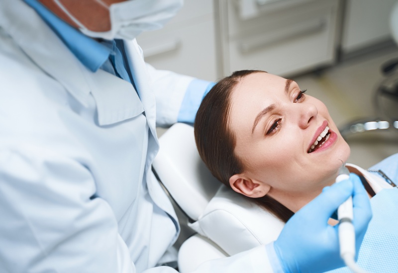 A dentist performing cosmetic dental treatment on a patient in a clinic in Charles Town, WV