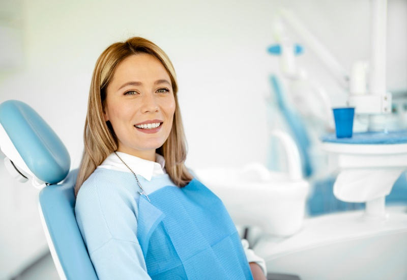 Smiling woman relaxing in a dental chair in a clinic after Curodont™ treatment in Charles Town, WV